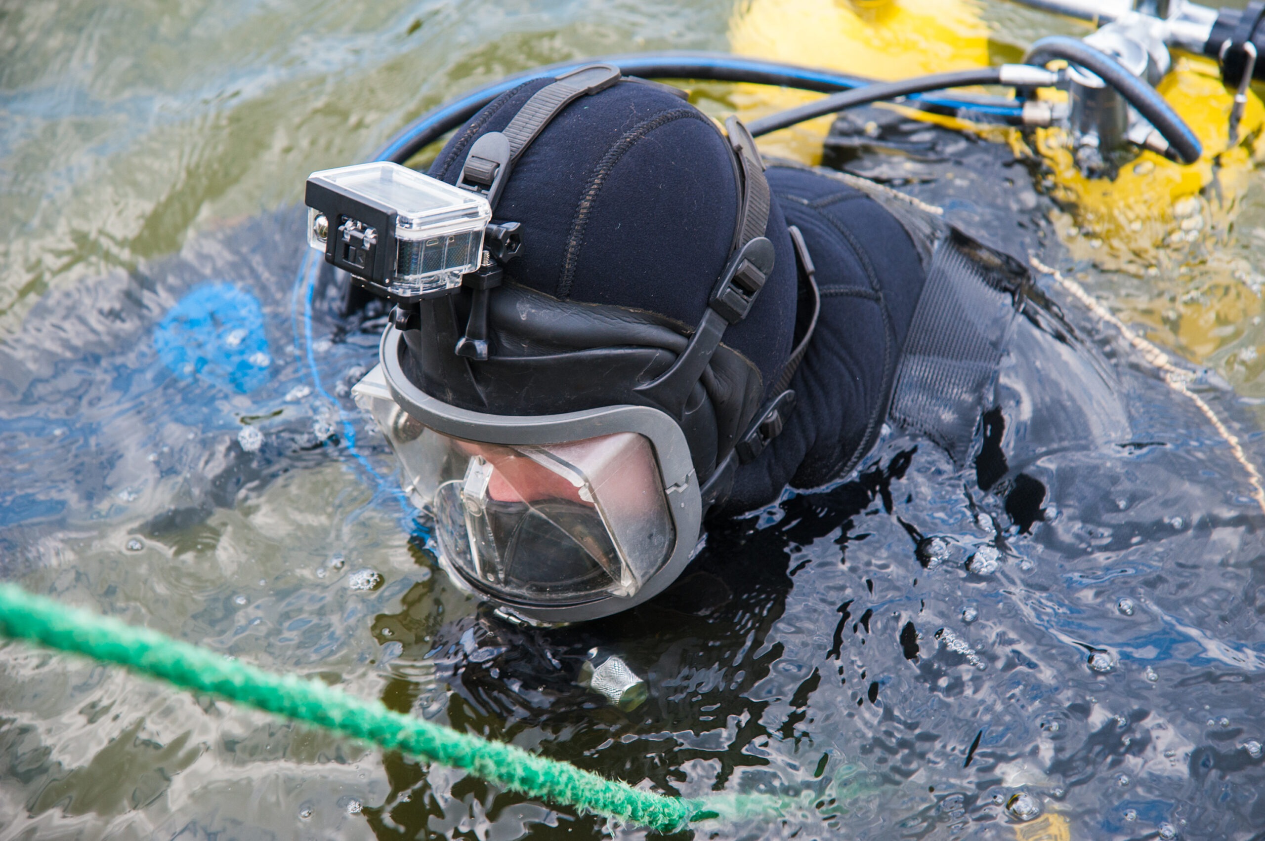 Diver in the Water in a Diving Suit and Helmet Ready to Dive